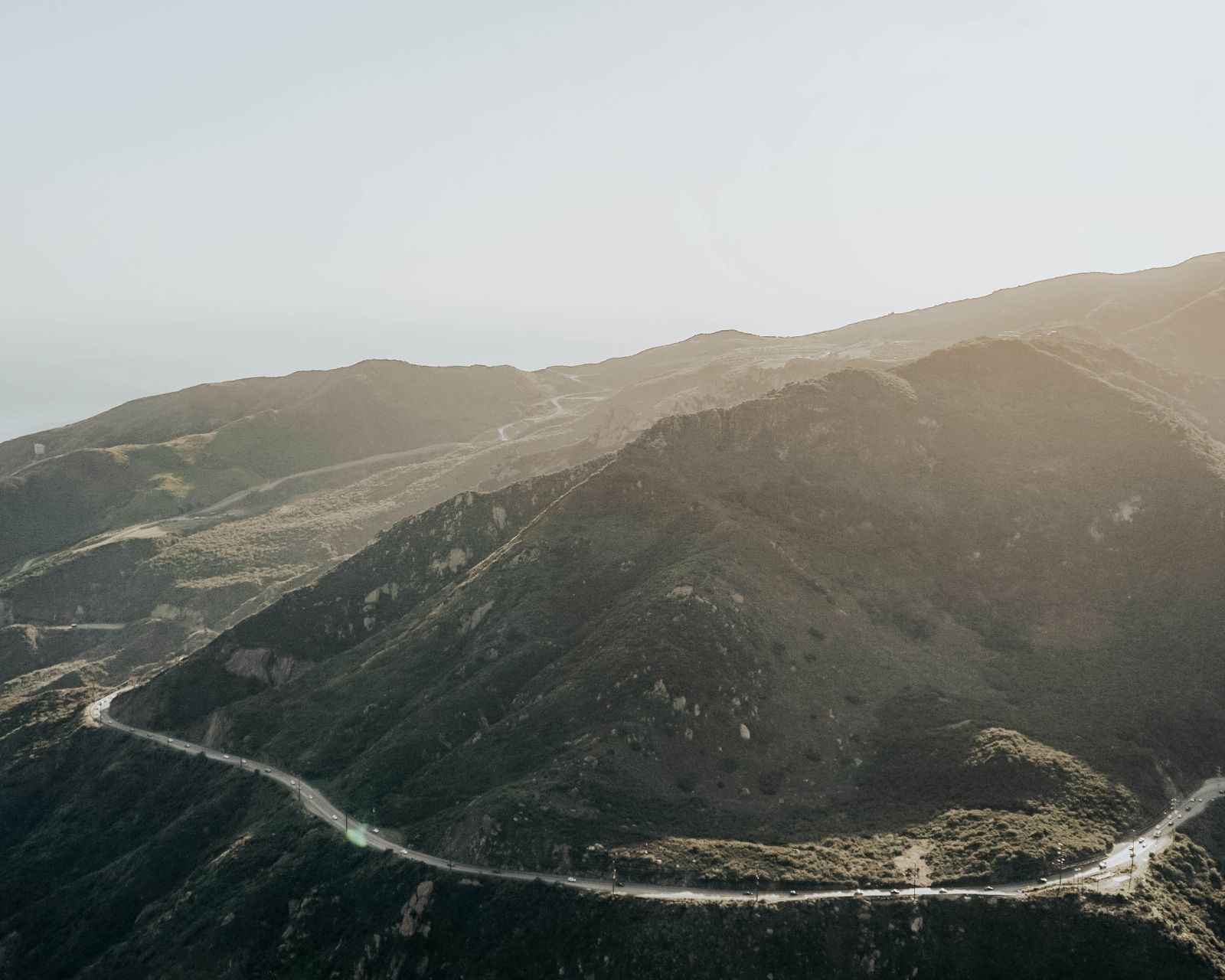 Road winding through mountain peaks at sunset